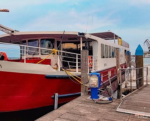 Das rot-weiße Hotelschiff Ave Maria liegt an einem hölzernen Steg in Venedig bereit für die Bike & Boat Tour nach Mantua.