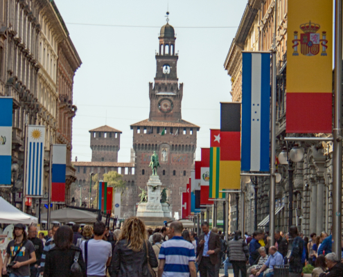 Via Dante mit Castello Sforzesco in Mailand Menschen spazieren die Via Dante im historischen Zentrum Mailands entlang in Richtung Castello Sforzesco.