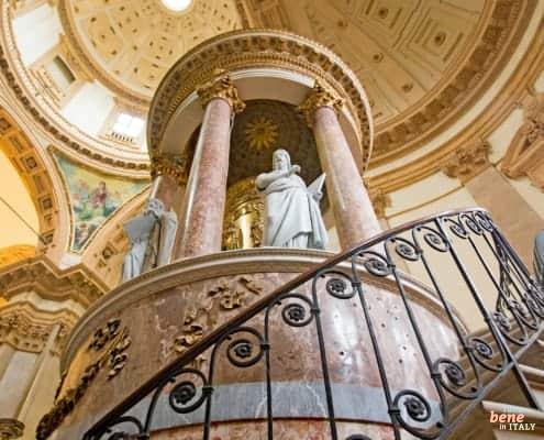 San Fedele – The Spiritual Home of La Scala's Artists • m24o Interior view of the magnificent San Fedele Church in Milan, showing the ornate pulpit and the impressive dome architecture.