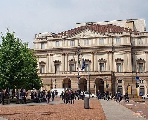 The Teatro alla Scala at Piazza della Scala in Milan with visitors and pedestrians during the day.