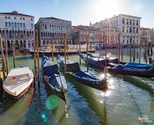 Classic gondolas moored at their stations on the Grand Canal in Venice in front of magnificent historic palaces in the sunlight. Title: Venice in the Sunshine: Gondolas on the Grand Ca