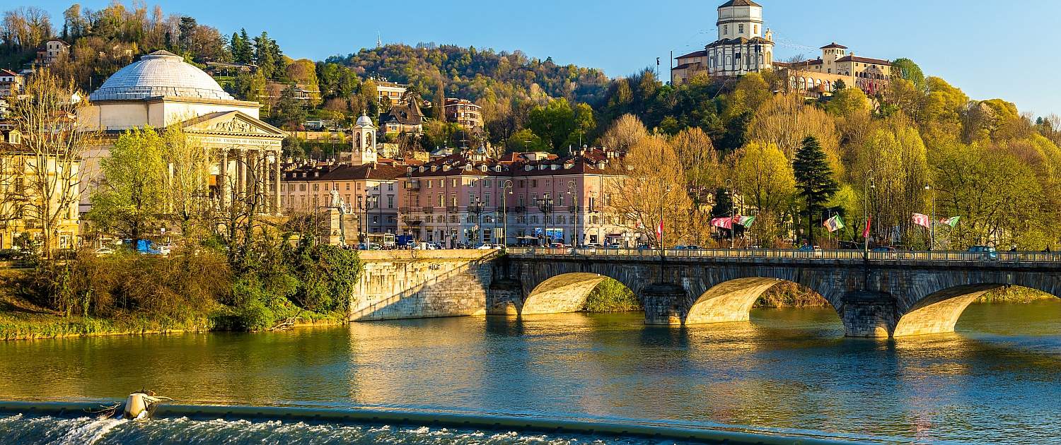 Turin Po River Gran Madre di Dio Monte dei Cappuccini Bridge View across the Po River with a weir towards the Gran Madre di Dio church and the Monte dei Cappuccini convent in Turin under a bright sky.