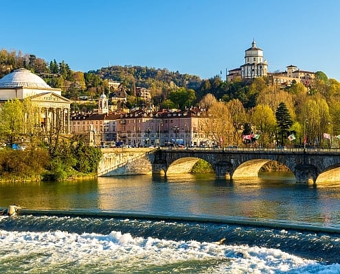 Turin Po River Gran Madre di Dio Monte dei Cappuccini Bridge • Copyright ©Leonid Andronov - stock.adobe.com View across the Po River with a weir towards the Gran Madre di Dio church and the Monte dei Cappuccini convent in Turin under a bright sky.