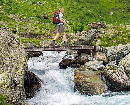 Hiking in Piedmont, crossing the Rio dell'Alpetto on a wooden bridge