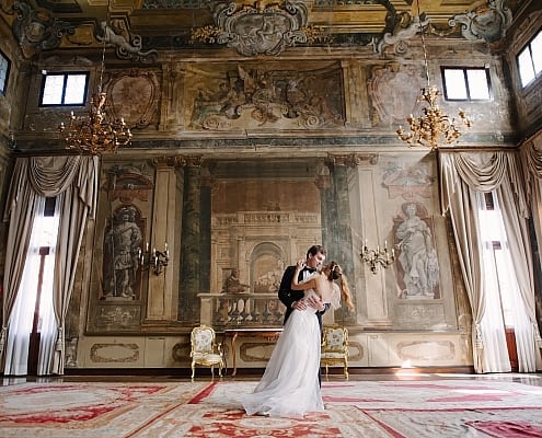 Romantische Hochzeit in Venedig – Heiraten in einem venezianischen Palazzo • ©tanialerro - stock.adobe.com Ein Brautpaar tanzt in einem prächtigen historischen Palast in Venedig vor antiken Fresken und goldenen Kronleuchtern; Foto © tanialerro - stock.adobe.com.