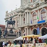 Palazzo Carignano Turin Carlo Alberto Monument Book Market • m24o A vibrant book and art market in front of the baroque brick facade of Palazzo Carignano in Turin featuring the Carlo Alberto monument.
