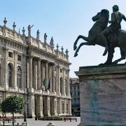 Palazzo Madama Turin Piazza Castello Facade Equestrian Statue • m24o The grand baroque facade of Palazzo Madama in Turin with a bronze equestrian statue in the foreground under a clear blue sky.