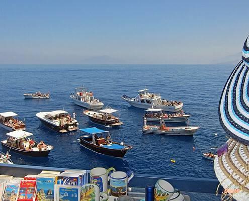Boats in front of the Blue Grotto of Capri entrance to the blue grotto