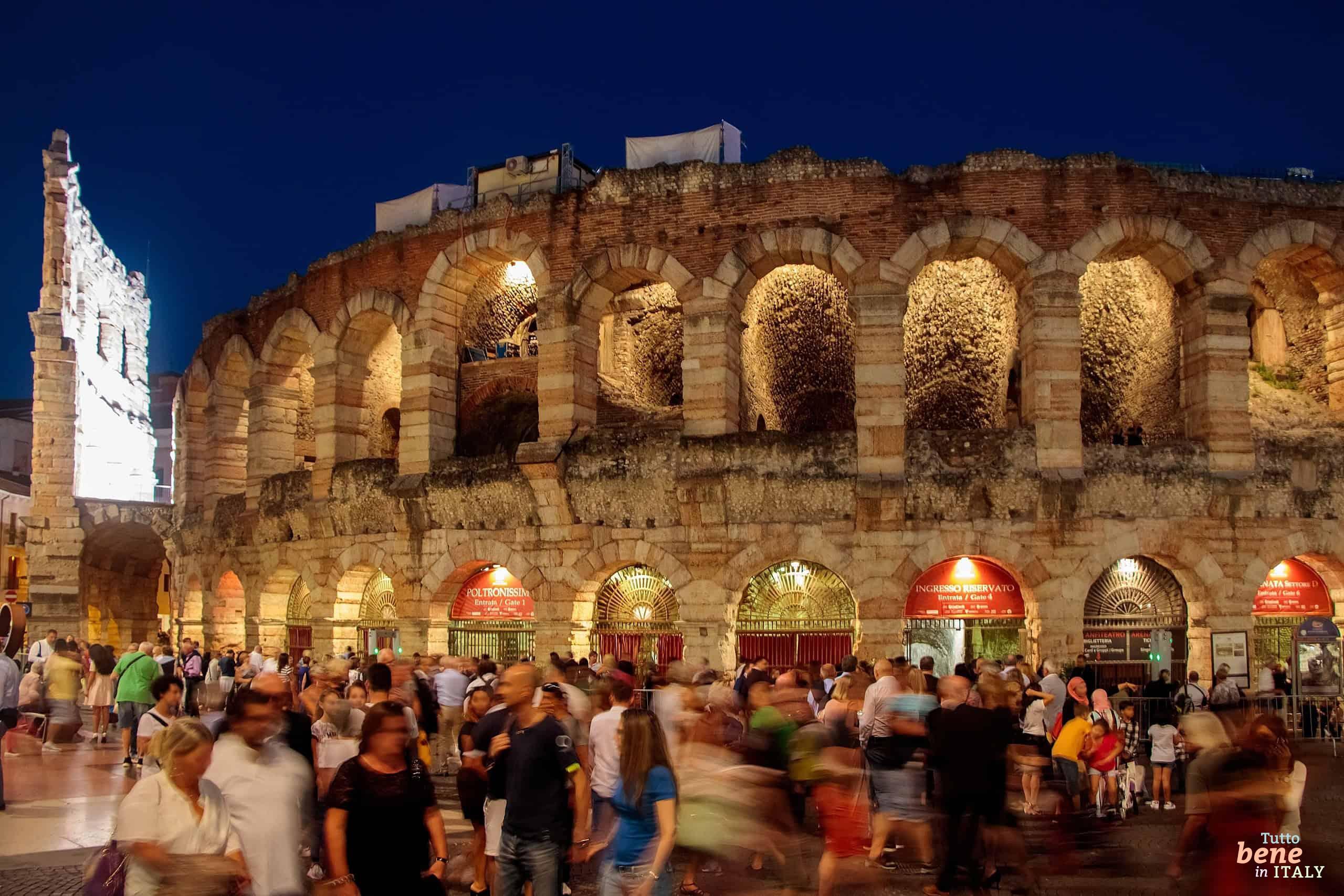Atmospheric night shot of the Arena di Verona with visitors at Piazza Brà during the Opera Festival.