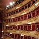 The historic gold-decorated boxes at Teatro alla Scala in Milan with red velvet lining and opera guests