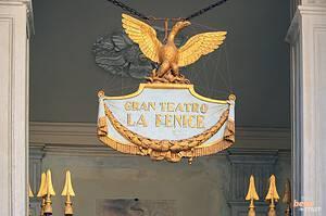 The magnificent golden phoenix emblem above the entrance of Teatro La Fenice in Venice, symbolizing the glorious rebirth of the opera house.
