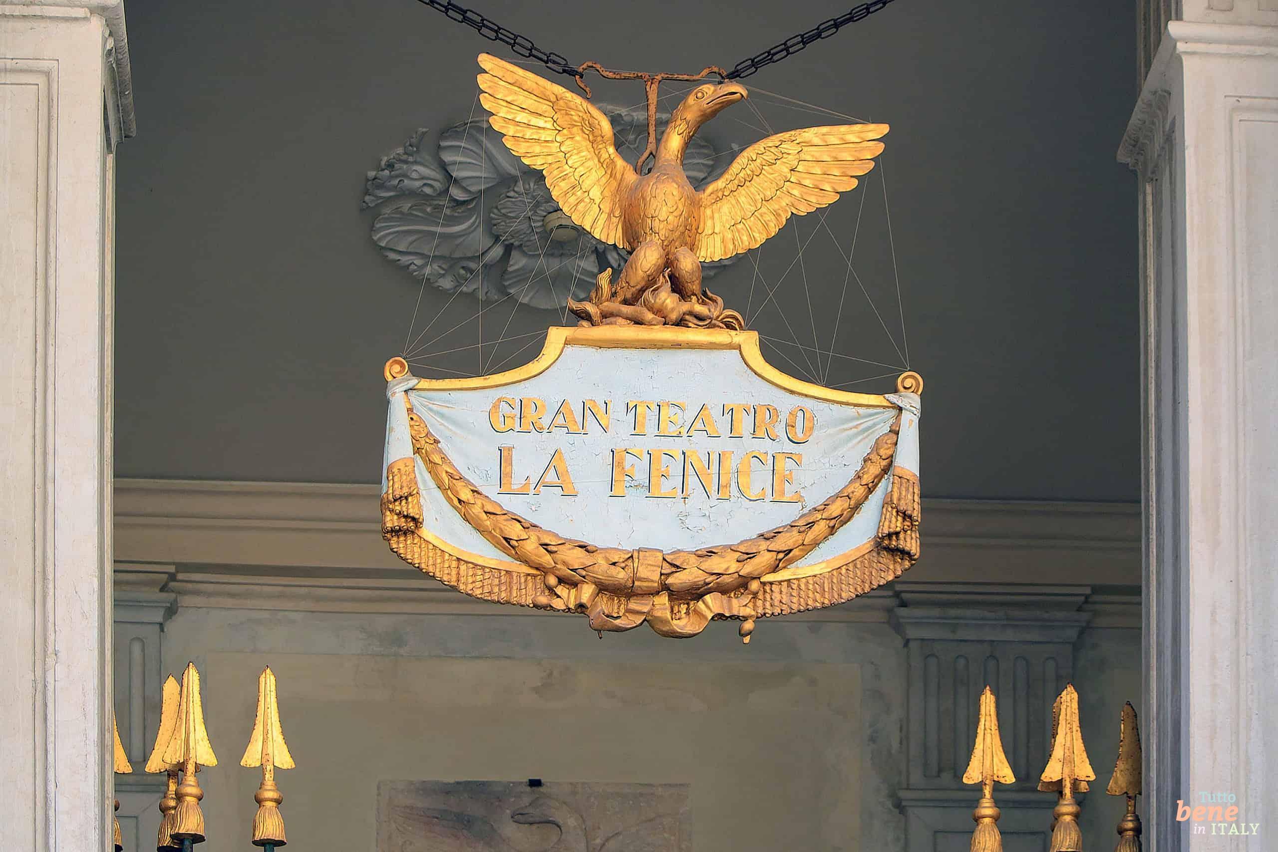 The magnificent golden phoenix emblem above the entrance of Teatro La Fenice in Venice, symbolizing the glorious rebirth of the opera house.