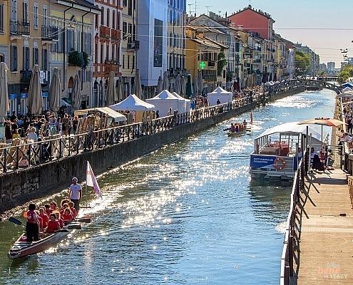 Naviglio Grande Milan – The Heart of Aperitivo Culture • m24o View along the Naviglio Grande in Milan featuring historic colorful houses reflecting in the canal waters.