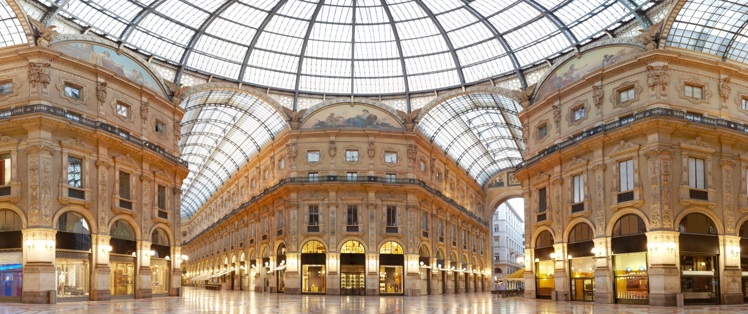 Panoramic view of the magnificent Galleria Vittorio Emanuele II in Milan, featuring its stunning glass dome and luxury facades.