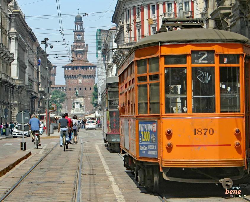 Eine historische Stra&szlig;enbahn in der Via Dante im Zentrum von Mailand und im Hintergrund das Castello Sforzesco, das Mail&auml;nder Schloss.