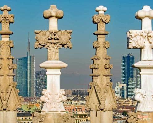 Mailänder Domspitzen vor der modernen Skyline • m24o Blick über die filigranen Fialen und Terrassenspitzen des Mailänder Doms hinweg auf die moderne Skyline von Mailand im Hintergrund.