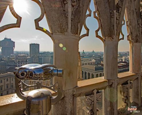 Mailänder Dom Dachterrasse: Infos & Tickets für die Terrassen • m24o Blick von der Dachterrasse des Mailänder Doms durch gotische Marmorbögen auf den Torre Velasca in der Skyline von Mailand.