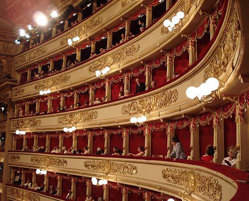 Private Boxes at Teatro alla Scala – Music Trips to Milan • ©Amro - stock.adobe.com The historic gold-decorated boxes at Teatro alla Scala in Milan with red velvet lining and opera guests