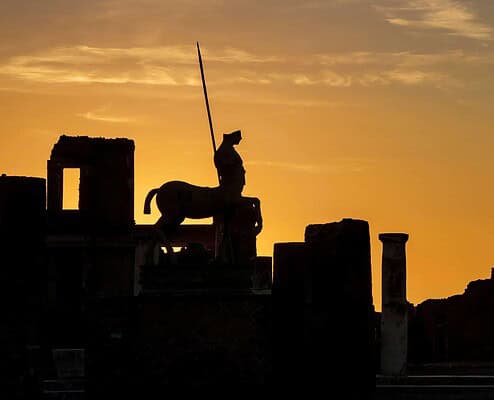 Ancient Greek statue at sunset • m24o Silhouette of the centaur statue by Igor Mitoraj in 1994 in the forum of the ancient city of Pompeii in Italy