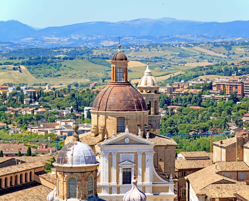 View over Macerata’s Dome into the Marche Countryside • m24o High-angle shot from a tower showing a prominent church dome in Macerata with the rolling hills of the Marche region in the background.